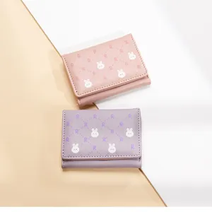 Close-up of pink and purple tri-fold wallets with cute rabbit and R-letter patterns