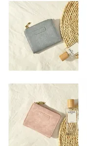 Close-up of minimalist leather short zipper wallets in grey and pink with elegant texture