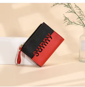 Detail of red and black PU leather wallet with lychee texture and wrist strap