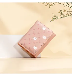Detail of light pink tri-fold wallet featuring cute rabbit and letter R floral patterns