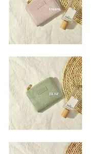 Detail view of cream and matcha green wallets with zip closure and pebble grain texture