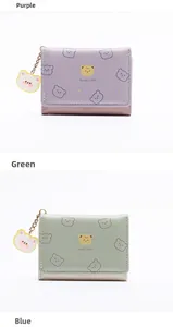 Detalle de carteras moradas y verdes con estampados de osos y colgantes de moda