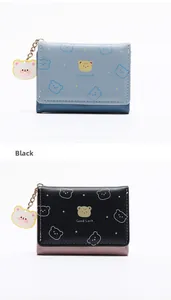 Detalle del estampado de oso y colgante en las carteras plegables azules y negras