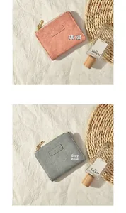 Detailed view of compact zip wallets in pink and blue with premium textured leather finish