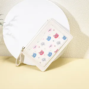 Close-up of minimalist cartoon bear print on beige leather wallet with zipper strap