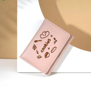 Gros plan d'un portefeuille en similicuir rose avec broderie cookies et coutures nettes