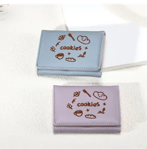 Détail de portefeuilles pliants en bleu et lilas avec broderie de biscuits mignons