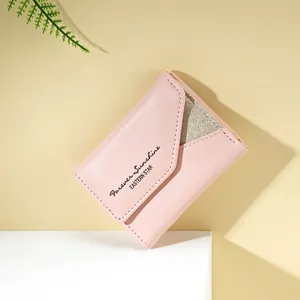 Dettaglio del portafoglio in pelle PU rosa con inserto glitter e scritte stampate