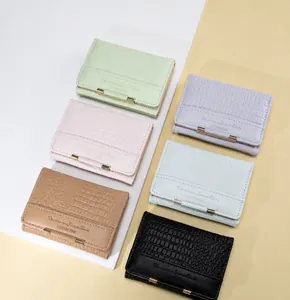 Close-up of faux crocodile leather texture and gold hardware on multi-color mini wallets