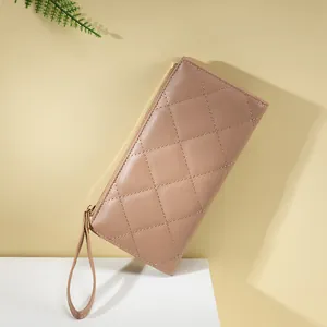 Close-up of nude faux leather long wallet with diamond quilted stitching and gold zipper