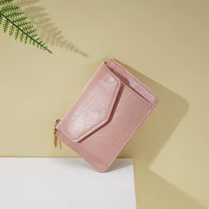 Détail du mini portefeuille rose en simili cuir avec texte doré et fermeture à glissière