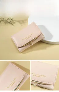 Detail showing the light pink leather purse with gold lettering and a pearl pendant