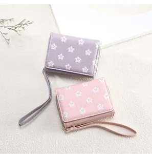 Detailed view of pink and purple bifold wallets with star patterns and wrist straps