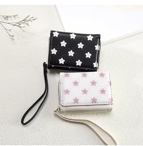 Detail view of cartoon star print purses with convenient wristlet straps and metal zippers
