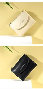 Dettaglio di portafogli corti in pelle beige e nero con design a patta e cerniera