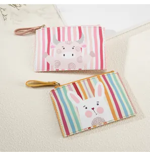 Dettaglio di portamonete in pelle PU con stampe di coniglietto e mucca e cinturino zip