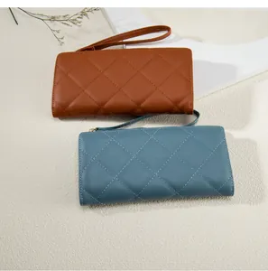 Detailed view of long quilted leather wallets in brown and blue-grey with wrist straps