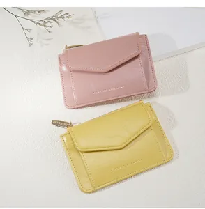 Vue détaillée des porte-monnaie en cuir rose et jaune avec fentes pour cartes et dorure