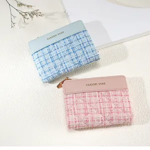 Close-up of light blue and pink tweed coin purses with quilted texture and gold zippers