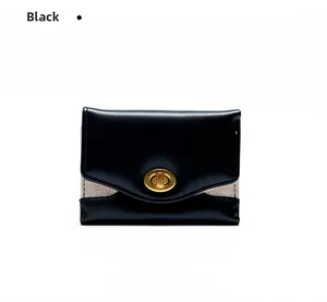 Dettaglio mini portafoglio in pelle nera con chiusura a scatto dorata e tocchi glitter