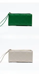 Detail view of quilted long wallets with wristlet straps in green and white colors