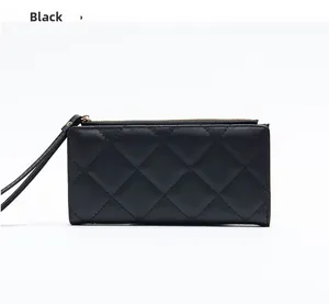 Detail view of black quilted faux leather long wallet with zipper and wrist strap