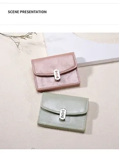 Detalle de mini carteras rosa y verde con hebillas metálicas en forma de cuchilla