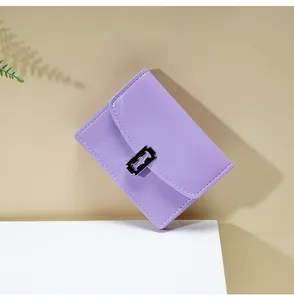 Detalle de cartera de cuero violeta con hebilla plateada decorativa en forma de cuchilla