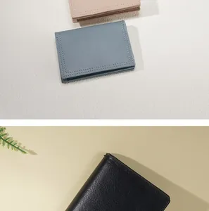 Vista dettagliata del portafoglio compatto multi-carte in pelle blu, rosa e nera