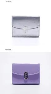 Primer plano de carteras mini de cuero plateado y morado con hebillas industriales