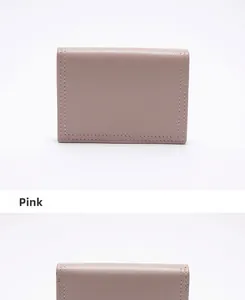 Dettaglio del portafoglio in pelle rosa con fessure per carte e cuciture di precisione