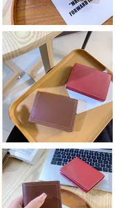 Gros plan de portefeuilles en cuir marron et rouge montrant les coutures et le grain litchi