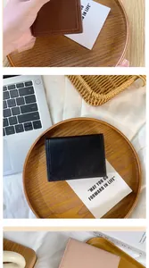 Vue détaillée de portefeuilles minimalistes en cuir en noir, marron et rose clair