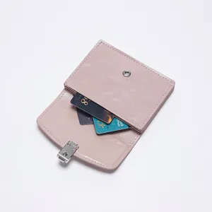 Cartera minimalista de cuero rosa con cierre de presión metálico y tarjeteros