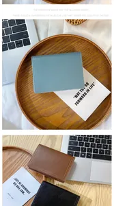 Gros plan de portefeuilles en cuir minimalistes en bleu, marron et noir avec coutures fines