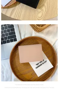 Détail d'un portefeuille en cuir minimaliste avec coutures de précision sur bois