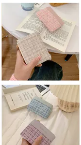 Détail de mini portefeuilles en tweed et cuir avec fermetures éclair dorées pastel