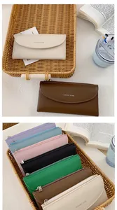 Dettaglio di portafogli lunghi multicolore con scomparti zip e tasche a patta