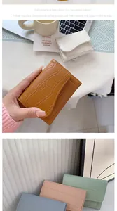 Dettaglio di un piccolo portafoglio a motivo coccodrillo con cuciture fini e vari colori