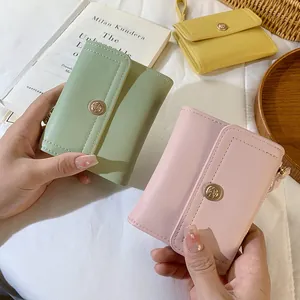 Tre portafogli corti minimalisti in colori pastello con fibbia a rosa sulla chiusura