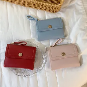 Tre portafogli in pelle minimalisti a tre ante in rosso, blu e rosa con emblema rosa