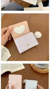 Detail of multi-color PU leather folding wallets with heart window and pompom charm
