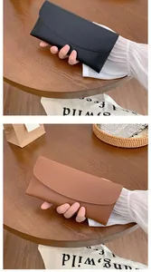 Detail of elegant long matte leather wallets in black and brown colors for women