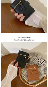 Detail of minimalist leather wallets with functional metal zippers and snap straps