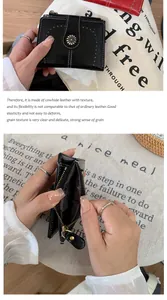 Dettaglio del portafoglio nero in pelle bovina con ciondolo a girasole e molti slot per carte