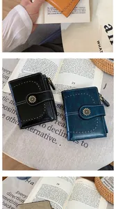 Dettaglio di portafogli in ecopelle vintage con fibbia a girasole e motivi traforati