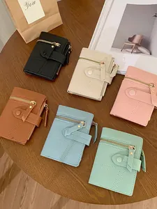 Short quilted faux leather wallets for women in six colors shown on a wooden table