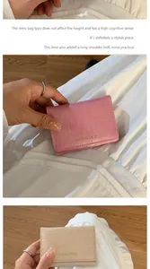 Dettaglio di mini portafogli rosa e beige con texture a coccodrillo e scritte dorate