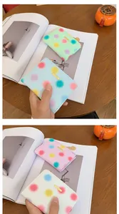 Dettaglio di un piccolo portafoglio a pois con logo su un tavolo in legno