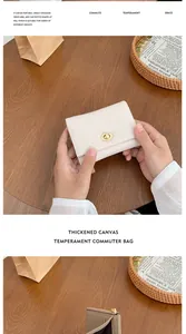 Dettaglio del portafoglio compatto in pelle beige con chiusura dorata su tavolo di legno